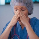 Stressed nurse with hands on her face Stressed nurse with hands on her face