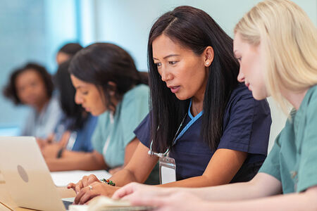 Two women getting their nursing certifications online