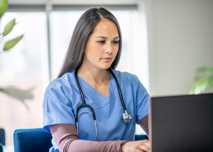 Nurse typing on a laptop